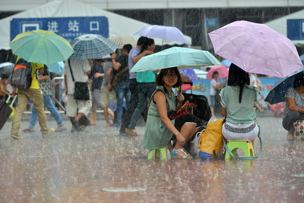 Passengers stranded at Guangzhou Railway Station wait for a refund after mudslides caused by a rainstorm paralyzed the southern section of the Beijing-Guangzhou rail line, one of the most important rail links connecting the nation's north and south, on Aug 18, 2013. [LIAO PAN / FOR CHINA DAILY]