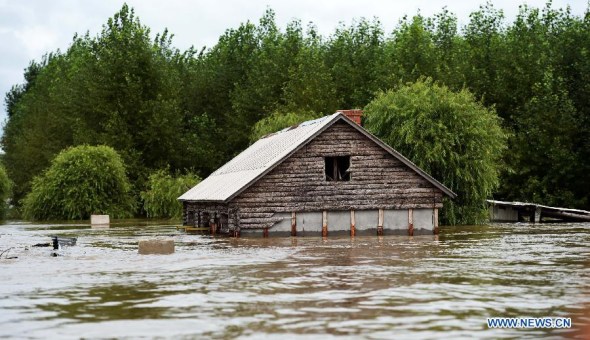 A half-submerged building is seen along the swollen Heilong River in Tongjiang City, northeast China's Heilongjiang Province, Aug. 19, 2013. The Heilongjiang Provincial Hydrological Bureau forecast the stretch of the Heilong River between Tongjiang and Fuyuan County will witness the largest flooding in its history. Authorities in Tongjiang have started a Grade I response preparing for floods. (Xinhua/Wang Kai) 