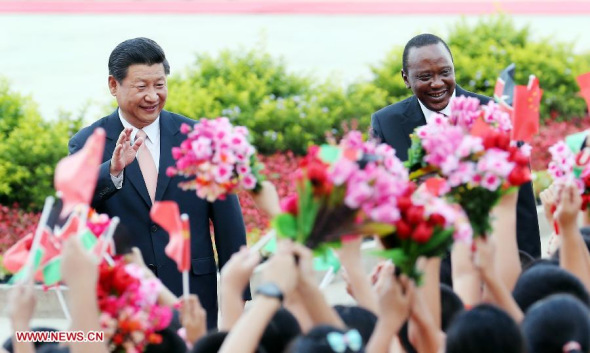 Chinese President Xi Jinping (L) and his Kenyan counterpart Uhuru Kenyatta greet the children as attending a welcoming ceremony for Kenyatta in Beijing, capital of China, Aug. 19, 2013. The two presidents later held talks at the Great Hall of the People in Beijing on Monday. (Xinhua/Yao Dawei)
