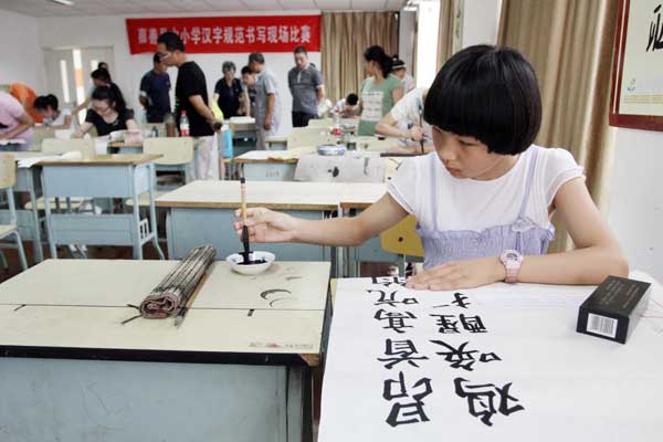 A student takes part in a calligraphy competition in Jiashan county, Zhejiang province, in August. Ten of the 50 participants will go to Jiaxing for a follow-up competition. Hu Lingxiang / for China Daily