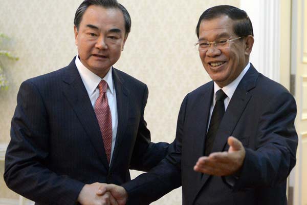 Chinese Foreign Minister Wang Yi (left) meets Cambodian Prime Minister Hun Sen at the Peace Palace in Phnom Penh on Wednesday. Wang Yi arrived in Cambodia on Tuesday for an official visit. [TANG CHHIN SOTHY / Agence France-Presse]