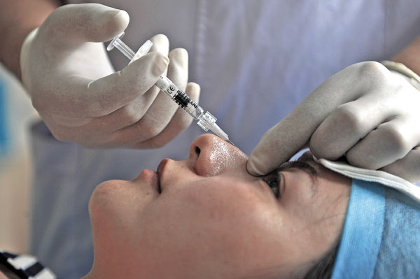 Zhejiang province's Jiaxing Shuguang cosmetic Surgery Hospital's physician prepares an artificial insert for a nose job. China ranked first in Asia and third in the world, after the United States and Brazil, in the number of cosmetic procedures conducted in 2011. Provided to China Daily