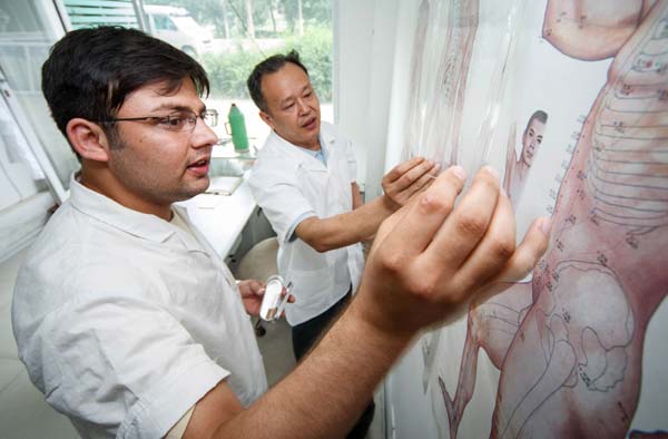 A Pakistani student, whose Chinese name is Mu Yang, studies traditional Chinese medicine at a clinic in Nantong, Jiangsu province. The 25-year-old graduated from Nantong University earlier in the summer. Huang Zhe / Xinhua