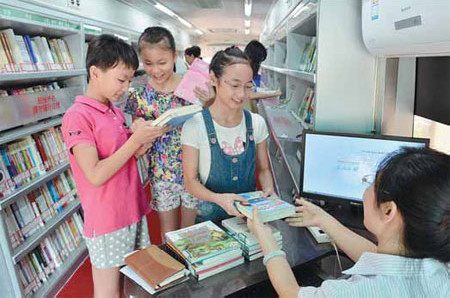 Students borrow books at the mobile library in Shijiazhuang, Hebei province. The converted bus has proved popular this month. Chen Tengfei / for China Daily