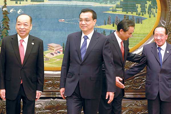 Premier Li Keqiang (center) and Foreign Minister Wang Yi (second from right) meet foreign ministers from member countries of the Association of Southeast Asian Nations during an event to mark the 10th anniversary of the strategic partnership between China and ASEAN at the Great Hall of the People in Beijing on Thursday. Also pictured are Bruneian Foreign Minister Mohamed Bolkiah (left), Thai Foreign Minister Surapong Tovichakchaikul (second from left), and Cambodian Foreign Minister Hor Namhong. [FENG YONGBIN / CHINA DAILY]