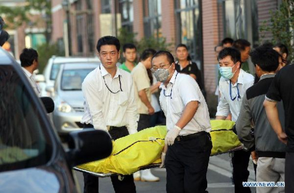 Workers carry the body of a victim of a leak accident in the Baoshan District of Shanghai, east China, Aug. 31, 2013. At least 15 people died and 26 others were injured after a liquid ammonia leak at the refrigeration unit of the Shanghai Weng's Cold Storage Industrial Co. Ltd. on Saturday, local authorities said. (Xinhua/Pei Xin)