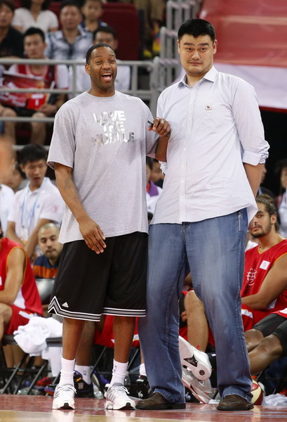 Retired Chinese and NBA basketball star Yao Ming (R) and Tracy Mcgrady react as they watch children's basketball match during the break of a charity basketball match between NBA All-star team and Chinese National team in Beijing July 1, 2013. [Photo/Agencies]