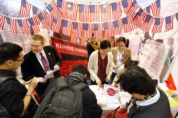 Students and parents ask for information at a college fair in Beijing in March. A report says fewer Chinese students applied to US graduate schools this past year. (Photo: Xinhua)