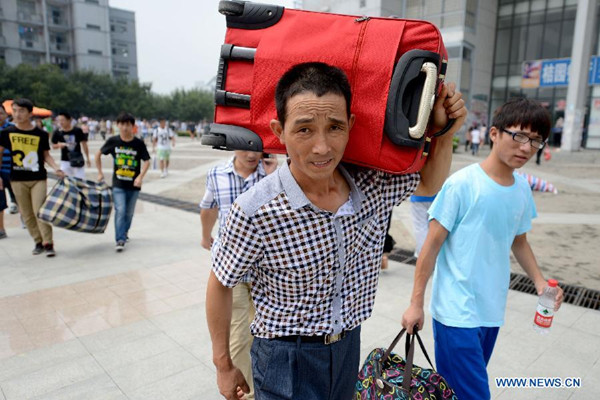 A parent helps his child carrying luggage at the Anhui University in Hefei, capital of east China's Anhui Province, Aug. 27, 2013. Undergraduates for 2013 registered on the day. The university recruited 5,097 freshmen this year. (Photo/Xinhua)