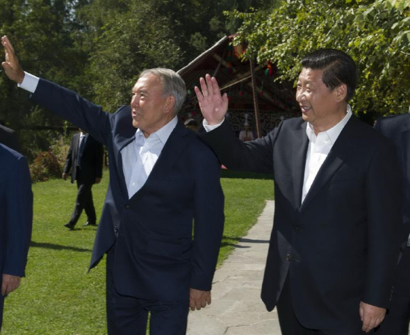 Chinese President Xi Jinping (R) and Kazakh President Nursultan Nazarbayev wave as they walk in Medeo park in Almaty, Kazakhstan, Sept. 8, 2013. Xi Jinping and Nursultan Nazarbayev held a meeting here on Sunday. (Xinhua/Huang Jingwen) 