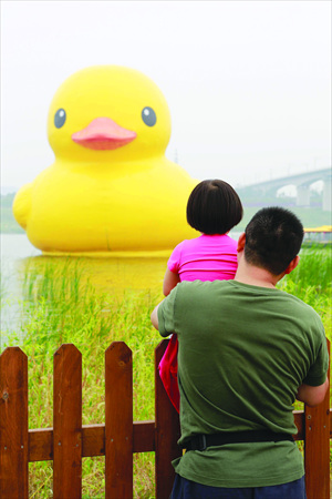 A father and daughter enjoy Rubber Duck after its emergency beak repairs. Photo: Li Hao/GT