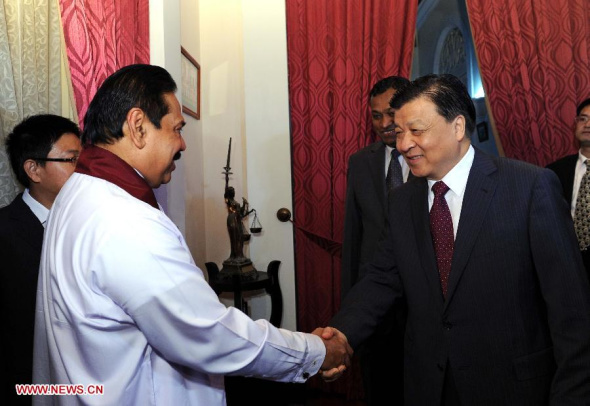 Liu Yunshan (R, front), a member of the Standing Committee of the Political Bureau of the Communist Party of China (CPC) Central Committee, shakes hands with Sri Lanka President Mahinda Rajapaksa, who is also head of the Freedom Party, in Colombo, capital of Sri Lanka, Sept. 10, 2013. (Xinhua/Rao Aimin)