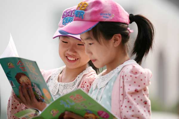 Two students enjoy reading at a bookstore in Nanjing, Jiangsu province. The central government released a circular calling for stricter supervision over children's publications to filter obscene and violent content. Wang Xin / for China Daily