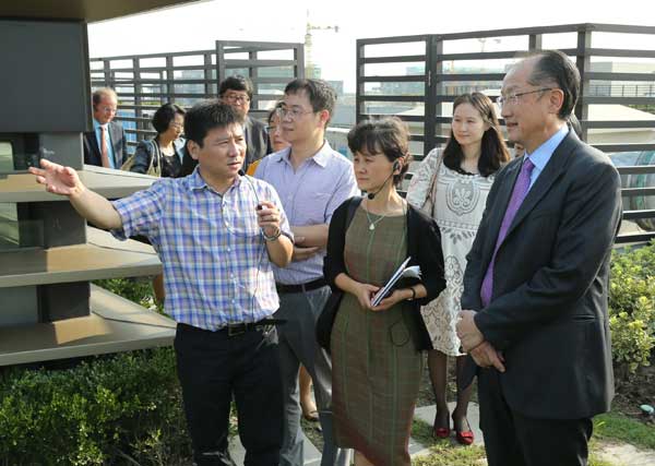 World Bank President Jim Yong Kim (right) learns about the design of a green building in Shanghai on Sunday. He began a four-day trip to China to promote low-carbon development. Wu Zhiyi / China DAILY