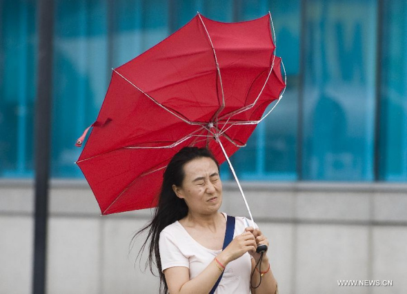 A woman's umbrella is turned over due to strong wind caused by Super typhoon Usagi in south China's Hong Kong, Sept. 22, 2013. Super typhoon Usagi moves to Southern Chinese coastal provinces at a speed of up to 20 km per hour and is expected to hammer Hong Kong's neighbouring Guangdong Province on Sunday night, according to local authorities. (Xinhua/Lui Siu Wai) 