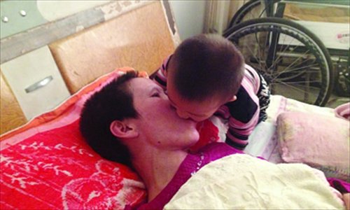 Son Gao Qianbo feeds a fried snack into mother Zhang Rongxiang mouth after she recently woke up paralyzed from a car accident in 2010 in Shuyang, Jiangsu Province on September 19. Photo: Yangtze Evening Post