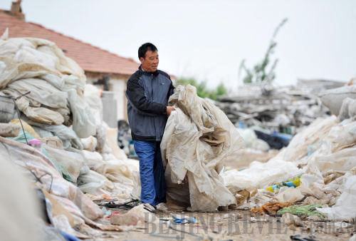 Wang Furong sorts used plastic mulch for recycling at his workshop in Mingrong Village in Xiji County, Ningxia Hui Autonomous Region. (Peng Zhaozhi)