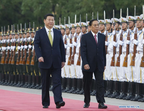 Chinese President and General Secretary of the Communist Party of China Central Committee Xi Jinping (L) and visiting Lao President and secretary general of the Central Committee of the Lao People's Revolutionary Party Choummaly Saygnasone review an honor guard in Beijing, capital of China, Sept. 26, 2013. Xi Jinping held talks on Thursday with Choummaly Saygnasone in Beijing. (Xinhua/Xie Huanchi)