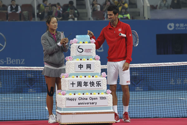 Chinese tennis player Li Na and Novak Djokovic from Serbia share a cake to celebrate the 10th anniversary of the China Open on Friday.[Photo/China Daily] 