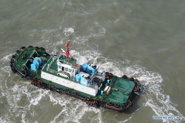 A rescue ship works at the accident site where a fishing boat sank, at the Changxing Island sea area near Dalian City, northeast China's Liaoning Province, Sept. 28, 2013. Two people on board have been rescued, while one is dead and another seven are still missing. The rescue work is underway. (Xinhua)