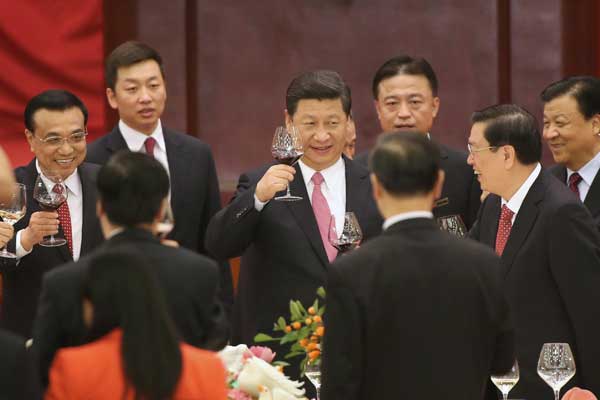 President Xi Jinping (center) and Premier Li Keqiang (left), along with other State leaders, propose a toast at a reception on Monday to mark the 64th anniversary of the founding of the People's Republic of China, which falls on Oct 1.[Xu Jingxing/China Daily]