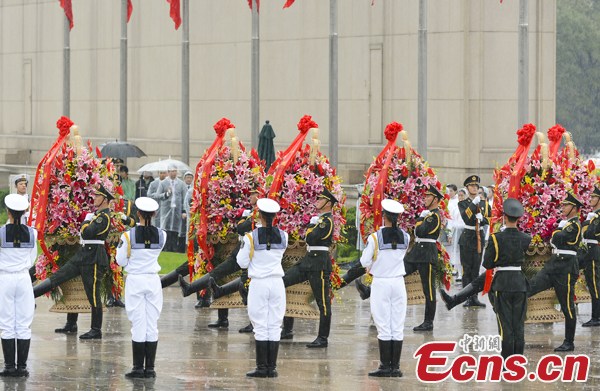 Soldiers carry the flower baskets in rain at the Monument to the People's Heroes in Tian'anmen Square of Beijing,  Oct  1, 2013, the National Day of China. (Photo: Liu Zhen / China News Service)