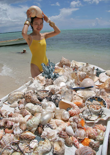 A vendor selling seashells attracts a Chinese tourist on the beach in Mauritius on Feb 10, 2005. Wu Kaixiang / Xinhua