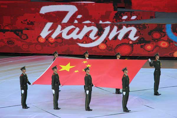 The national flag of the People's Republic of China is carried to the stadium during the opening ceremony of the 6th East Asian Games in north China's Tianjin, Oct. 6, 2013.[Xinhua/Liu Xu]