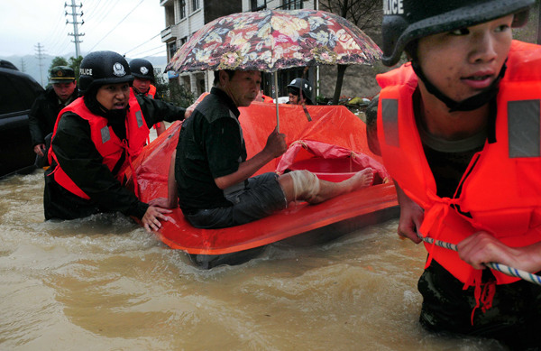 Rescuers transport an injured man to hospital in Wenzhou, Zhejiang province, in the aftermath of Typhoon Fitow on Monday. The man suffered a severed artery in his leg when the typhoon flooded his village, requiring rescuers to walk 10 kilometers to save him. Wu Shuibin / For China Daily
