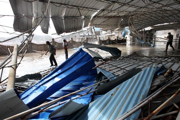 Workers repair the damaged roof of a market in Wenling City, east China's Zhejiang province, Oct. 7, 2013. Typhoon Fitow has affected over 3 million people in eight cities of Zhejiang, causing direct economic damage of 2.28 billion yuan (about 160 million US dollars). (Xinhua/Sun Jinbiao)