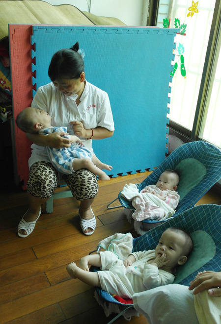 A caregiver looks after children at the Nanchang Child Welfare Home in Jiangxi province. He Dan / China Daily 