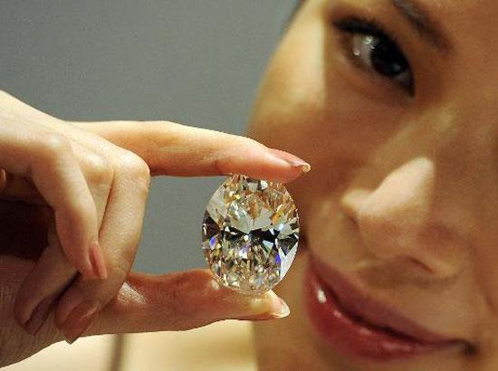 A model holds a flawless 118.28-carat white oval diamond during a media preview at Sotheby's auction house in Hong Kong on September 19, 2013.