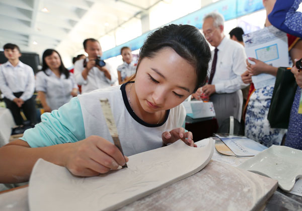 A Chinese student engraves a slab of porcelain during an exhibition for the vocational education cooperation between China and ASEAN in Guiyang, Guizhou province, on Sept 16. Peng Nian / For China Daily
