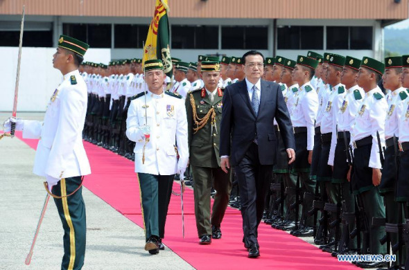 Chinese Premier Li Keqiang (4th L) reviews an honor guard during a grand welcome ceremony with Bruneian characteristics upon his arrival at the airport in Bandar Seri Begawan, Brunei, Oct. 9, 2013. At the invitation of Brunei Sultan Hassanal Bolkiah, Li arrived here Wednesday and started an official visit to the country. (Xinhua/Liu Jiansheng)