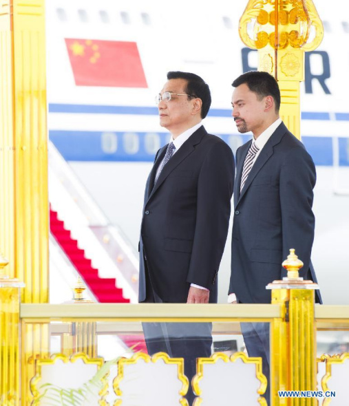 Chinese Premier Li Keqiang (L) attends a grand welcome ceremony with Bruneian characteristics held by Crown Prince of Brunei Haji Al-Muhtadee Billah upon his arrival at the airport in Bandar Seri Begawan, Brunei, Oct. 9, 2013. At the invitation of Brunei 