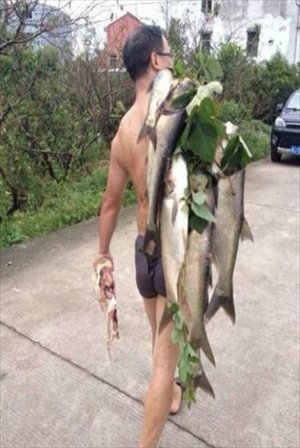 A villager carries several big fish caught in flood discharge from the Changtan reservoir in Taizhou, Zhejiang Province on October 5. Photo: chinanews.com