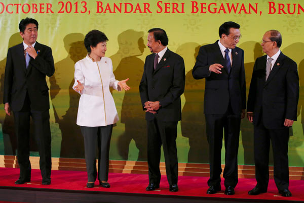 (From left to right) Japanese Prime Minister Shinzo Abe, South Korean President Park Geun-hye, Brunei Sultan Hassanal Bolkiah, Chinese Premier Li Keqiang, and Myanmar President U Thein Sein gather for a group photo at the ASEAN Plus Three Summit on Thursday. Vincent Thian / Associated Press