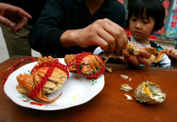 People enjoy steamed hairy crabs at a restaurant in Suzhou of Jiangsu province, China. [File photo]