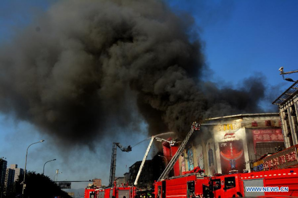Photo taken on Oct. 11, 2013 shows the Xilongduo shopping mall on fire in the Shijingshan District of Beijing, capital of China. (Xinhua/Li Wenming)