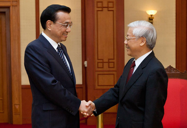 Premier Li Keqiang (left) shakes hands with Vietnamese General Secretary of the Communist Party Nguyen Phu Trong at the Party Central Committee Office in Hanoi on Monday. Li will return from his visit to Vietnam on Tuesday. Luong Thai Linh / Reuters
