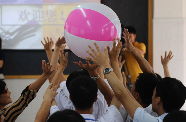 Teachers, students and parents take part on the first day of an arts and craft class for mentally challenged students at Guangzhou Haizhu Business Vocational School on Monday. Ye Weibao / For China Daily