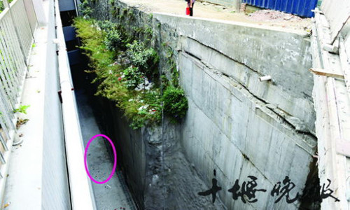People examine the site where a 17-year-old female student fell to her death while walking along the path above and playing with a cellphone on October 10 in Shiyan, Hubei Province. There are still traces of blood below. Photo: Shiyan Evening News