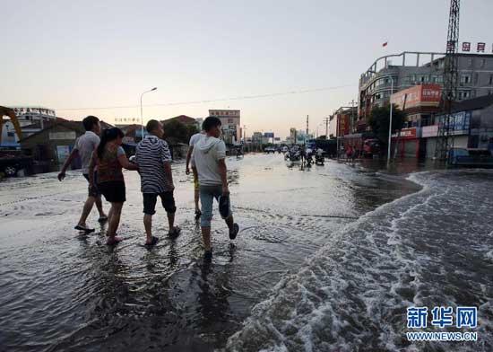 The floodwater retreats slowly on Yangming road in the downtown Yuyao City, east China's Zhejiang Province, Oct. 12, 2013. (Xinhua/Guo Bin)