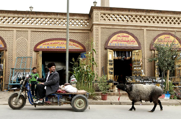 Uygurs drag a sheep home on Sunday to prepare for Eid-al-Adha in Kashgar. Photos by Feng Yongbin / China Daily