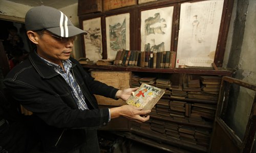 Sun Lide shows one of the more than 2,000 books that his grandfather, Lin Daozhi, kept at the request of a Jewish refugee from Germany who left the city in 1943. Photo: Cai Xianmin/GT