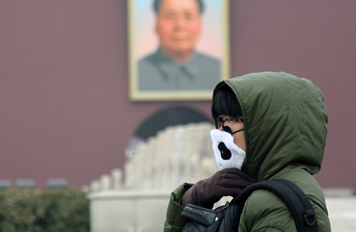 A woman stands before smog-shrouded Tiananmen Gate in Beijing, capital of China, Feb. 17, 2013. [Photo: Chinanews.com]