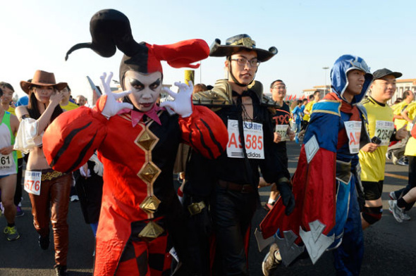 Runners wearing fancy costumes start from Tian'anmen Square during the Beijing International Marathon on Sunday morning. The event attracted 30,000 runners. Tadese Tola of Ethiopia broke the event record set 27 years ago to win the men's race, finishing with 2:07:16. PHOTO Provided to China Daily