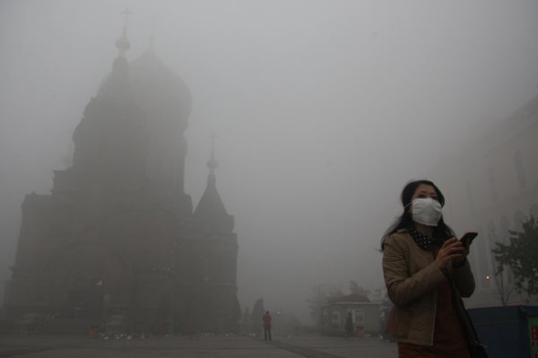 Heavy smog shrouds Harbin, Heilongjiang province, on Monday, as schools were closed and some buses stopped operating because of poor visibility on the roads. Photo by Xiao Gang / For China Daily