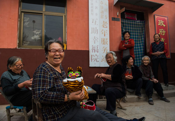 Residents of a home for the elderly in Feixiang county, Hebei province, share a laugh. China's pension system faces pressing challenges as the number of people of working age continues to fall. Pan Songgang / For China Daily