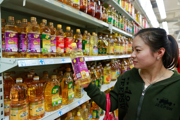 A consumer chooses oil made from non-genetically modified sunflower seeds in a supermarket in Beijing on Tuesday. Feng Yongbin / China Daily